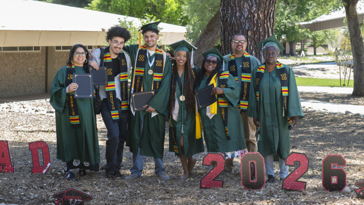 Image of Umoja students standing behind a banner