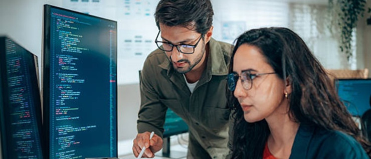 Two people working on programming code