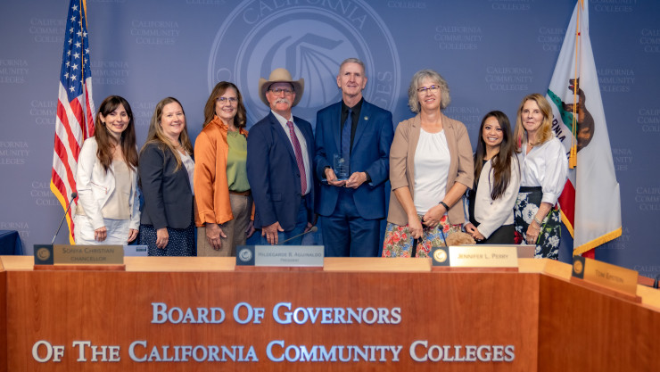 Group photo of people behind a desk labeled “Board of Governors of the California Community Colleges.”