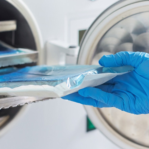 Image of a hand holding a plastic bag with blue contents