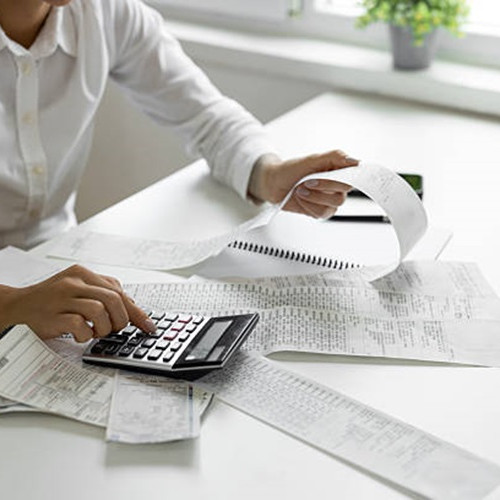 Person at desk using calculator
